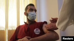 A man receives a dose of the coronavirus vaccine at a hospital in Idlib, Syria, May 1, 2021. 