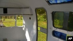 This is the interior of a much bigger Airstream, parked in a tranquil setting.