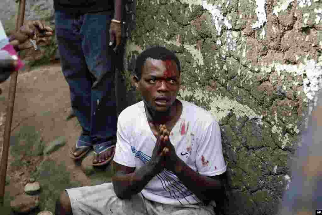 Jean Claude Niyonzima pleads for his life as he is surrounded at his house by demonstrators in Bujumbura, May 7, 2015.