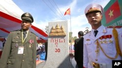 រូបឯកសារ៖ មន្ត្រី​ព្រំដែន​របស់​កម្ពុជា​(ឆ្វេង) និង​​មន្ត្រី​ព្រំដែន​របស់​វៀតណាម​ឈរ​នៅ​ខាង​មុខ​បង្គោល​ព្រំដែន​ថ្មី​មួយ​​លើ​ទឹក​ដី​កម្ពុជា រវាង​ខេត្ត​ Gia Lai របស់​វៀតណាម និង​ខេត្ត​រតនគីរី​របស់​កម្ពុជា កាល​ពី​ថ្ងៃ​សៅរ៍ ទី​២៦ ខែធ្នូ ឆ្នាំ​២០១៥។ 