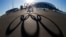 The Olympic rings are cast in shadow as the sun sets behind the Bolshoy Ice Palace as preparations continue at the Olympic Park for the 2014 Winter Olympics in Sochi, Russia, Feb. 3, 2014.