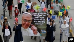 FILE - Nuns hold a banner with an image of Pope Francis and a message that reads in Spanish: "I ask you in the name of God to defend Mother Earth" during a silent march calling for action to tackle climate change, in Bogota, Colombia, Nov. 29, 2015.