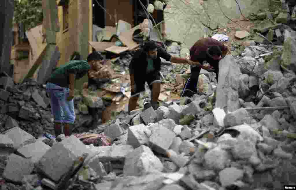 Palestinians search for the remains of bodies under the rubble of the Abu Nejim family house which witnesses said was destroyed by an Israeli air strike in Jabaliya refugee camp in the northern Gaza Strip, August 4, 2014.