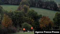 FILE - Hunters walk with a dog in Montamel, southwestern France, Nov. 7, 2021. Some people are accusing EU officials of introducing bears to the wild without considering the impact on local communities.
