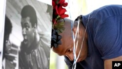 Seorang pria meletakkan balon untuk mengenang Muhammad Ali di luar Scottsdale Osborn Medical Center, Sabtu, 4 Juni 2016, di Scottsdale, Arizona .