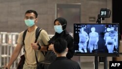 Pemeriksaan suhu di Bandara Internasional Changi di Singapura, 27 Februari 2020. (Foto: AFP)