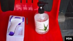 រូបឯកសារ៖ ម៉ាស៊ីន​វាស់​កម្តៅ​មួយ ​និង​ទឹក​អាល់​កុល​លាង​ដៃ​មួយ​ដប​ នៅ​មុខ​ហាង​លក់​គ្រឿង​សម្អាង​មួយកន្លែង នៅរាជធានីភ្នំពេញ កាលពីថ្ងៃទី២៧ ខែមីនា ឆ្នាំ២០២០។