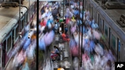 FILE- Women rest on a bench at the churchgate railway station during peak hours in Mumbai, India, Thursday, March 20, 2023. India’s Parliament has approved landmark legislation that reserves 33% of the seats in its powerful lower house and in state legislatures for women.