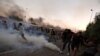 Sejumlah demonstran tampak berlarian saat petugas keamanan Irak berusaha membubarkan massa dengan menembakkan gas air mata dalam aksi protes antipemerintah di Baghdad, Irak, pada 5 Oktober 2019. (Foto: Reuters/Thaier Al-Sudani) 