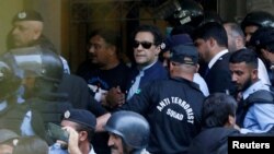 FILE - Officers escort Pakistan's former Prime Minister Imran Khan as he appears in Islamabad High Court on May 12, 2023. Pakistan's top court approved bail for Khan on Dec. 22, but because he is serving a sentence for an earlier conviction, he has not been released.