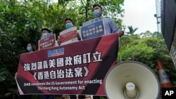 Beijing supporters carry a banner during a protest against the U.S. sanctions outside the U.S. Consulate in Hong Kong Thursday, July 16, 2020. China has accused the U.S. of seeking to obstruct its development with moves to sanction officials who…