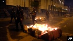 Riot police run during clashes with supporters of ousted President Pedro Castillo in front of Congress in Lima, Peru, Dec. 11, 2022.