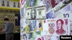 FILE - A customer is served at a counter at a foreign exchange store in Hong Kong, China, Aug. 13, 2015. 