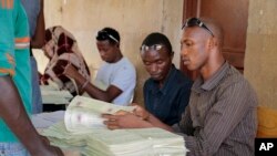 FILE - A new Burundi electoral schedule has been proposed for a July 15 presidential election. Here, election workers distribute voter cards in the capital, Bujumbura, June 4, 2015. 