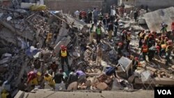Warga dan tim penyelamat mencari korban di balik reruntuhan bangunan pabrik di Lahore (6/2).