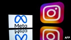 FILE - This photograph taken on Jan. 12, 2023, shows a smartphone and a computer screen displaying the reflected logos of Instagram app and its parent company Meta in Toulouse, south-western France.