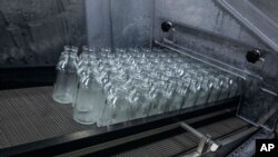 FILE - Bottles for medication are sanitized at the Eva Pharma facility in Cairo, Egypt, July 12, 2020. Eva Pharma is producing two drugs used in the treatment of COVID-19 patients — remdesivir and avipiravir.