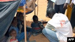 Un employé de Médecins sans frontières examine des enfants souffrant de malnutrition dans un camp de réfugiés maliens situé à Chinegodar, dans l'ouest du Niger, près de la frontière malienne, le 4 février 2012. (AFP PHOTO / BOUREIMA HAMA)