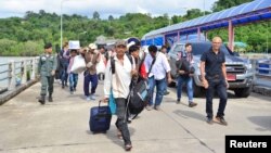 A group of Myanmar migrant workers cross the border between Thailand and Myanmar near the Thai port city of Ranong, July 3, 2017.
