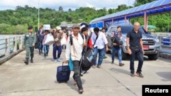 A group of Myanmar migrant workers cross the border between Thailand and Myanmar near the Thai port city of Ranong, July 3, 2017.