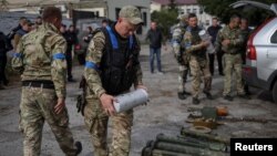 Сапер міліції несе касету з протипіхотними мінами ПОМ-3 після повернення з селища Уди, нещодавно звільненого ЗСУ, у місті Золочів, Харківська область, Україна, 12 вересня 2022. REUTERS/Gleb Garanich