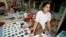 FILE - A woman from Myanmar sells rubies and other semi-precious stones at a market in Mae Sot, Thailand, Oct. 21, 2007. A U.S. a ban on the import of jadeite and rubies, one of Myanmar's most profitable industries, remains in place.
