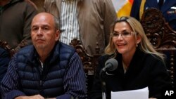 Accompanied by Government Minister Arturo Murillo, Bolivia's interim President Jeanine Anez speaks during a press conference at the presidential palace, in La Paz, Bolivia, Nov. 23, 2019. 