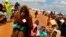 FILE - Somali refugees walk through an area housing new arrivals, on the outskirts of Hagadera Camp outside Dadaab, Kenya, Aug. 5, 2011. Residents of a new "integrated" settlement at Kalobeyei, in the country's northeast, complain that living conditions are not as they expected them to be.