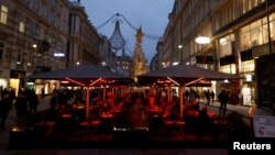 FILE - People sit in a cafe amidst the coronavirus disease (COVID-19) outbreak, in Vienna, Austria, Nov. 12, 2021. 