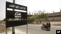 Logo al-Qaida terlihat di rambu jalan di kota Jaar di provinsi Abyan selatan, Yaman, 15 Juni 2012. (Foto: AP)