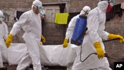 Petugas membawa jenazah koeban ebola di Monrovia, Liberia (10/11). Malaysia mengkarantina seorang mahasiswa asal Zimbabwe yang menunjukkan gejala Ebola.