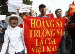 Vietnamese protesters carry a banner with a Vietnamese slogan reading, "Paracel islands and Spratly islands belong to Vietnam," during a protest demanding China to stay out of their waters.