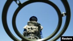 FILE - An anti-personnel mine detecting worker stands at a mine field near Vilancoulos in southern Mozambique, 450 km (265 miles) north east of Maputo, Nov. 2004 file photo. 