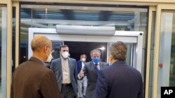 IAEA Director-General Rafael Mariano Grossi, second right, is welcomed by Deputy Head of the Atomic Energy Organization of Iran, Behrouz Kamalvandi, right, as he is accompanied by Iran's envoy to the IAEA, Kazem Gharibabadi, second left, in Tehran, Iran, 