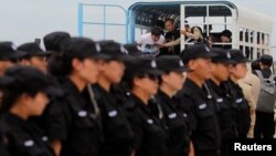 FILE - The Chinese police SWAT team lines up as suspects of telecom fraud arrive before their deportation to China at the International Airport of Phnom Penh, Cambodia June 24, 2016.