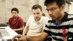FILE - Shiva Gopalan, a computer engineering masters student at Texas A&M University (far right), confers with IBM developers Henrique Copelli Zambon (center) and Luiz Aoqui, during an IBM hosted Spark Hackathon at Galvanize, a tech hub in San Francisco, June 14, 2015.