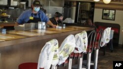 ថង់ប្លាស្ទិក​ត្រូវ​បាន​គេ​ដាក់​ដើម្បី​លើក​កម្ពស់​គម្លាត​សង្គម​នៅ​ភោជនីយដ្ឋាន Waffle House នៅ​ក្នុង​ក្រុង Savannah រដ្ឋ Georgia កាលពី​ថ្ងៃទី២៧ ខែមេសា ឆ្នាំ២០២០។