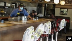 Plastic bags mark off seats to promote social distancing at a Waffle House restaurant in Savannah, Georgia, April 27, 2020.