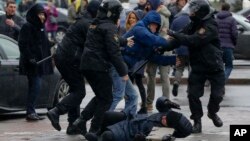 A woman, pushed to the ground by Belarus police, tries to defend herself during an opposition rally in Minsk, March 25, 2017. A cordon of club-wielding police blocked the demonstrators' movement along Minsk's main avenue near the Academy of Science. 
