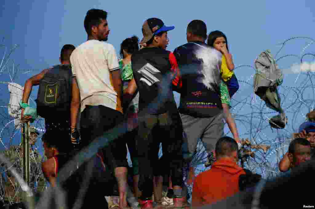 Asylum seekers wait on the banks of the Rio Bravo river after crossing during their journey through Mexico to Eagle Pass, Texas, in Piedras Negras, Mexico, Sept. 26, 2023.