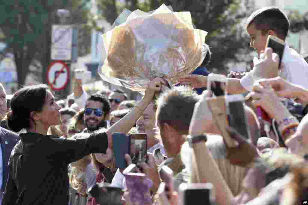 Meghan, Duchess of Sussex receives flowers from well-wishers during a visit to the Pavilion Building in Brighton, England.