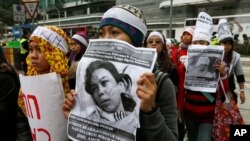 Para pekerja domestik dan pendukung mereka memegang gambar pembantu rumah tangga asal Indonesia, Erwiana Sulistyaningsih yang berusia 23 tahun dan disiksa secara brutal oleh majikannya di Hong Kong. (Foto: Dok)
