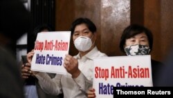 Members of the Atlanta Korean American Committee against Asian Hate Crime show placards as they meet at Ching Dam, a Korean restaurant, after the fatal shooting at three Georgia spas, in Duluth, Georgia, March 18, 2021.