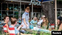 지난달 28일 미국 텍사스주 오스틴의 식당에서 마스크를 착용한 직원이 손님들의 주문을 받고 있다. 