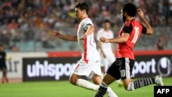 L'attaquant tunisien Youssef Msakni contre l'attaquant égyptien Mohamed Salah lors de son match de qualification pour la Coupe d'Afrique des Nations CAN 2019 à Rades, le 11 juin 2017.