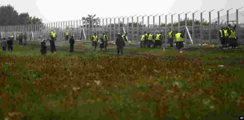 Hungarian workers build a partially constructed fence at their border with Serbia near Roszke, southern Hungary in Roszke, Sept. 11, 2015. EU officials and human rights groups say they've been disappointed by the animosity toward asylum-seekers in countri