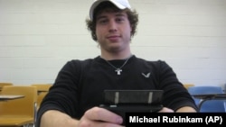 In this November 22, 2010 photo, Tom Markley, 21, of Lehighton, Pennsylvania, a senior at Wilkes University in Wilkes-Barre, Pennsylvania, poses with his phone in a Wilkes classroom.