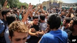Sekelompok pengunjuk rasa meneriakkan slogan-slogan di pintu utama Grand Bazaar lama di Tehran, Iran, 25 Juni 2018 (foto: Kantor Berita Tenaga Kerja Iran via AP)