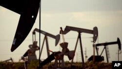 Pumpjacks bob in a field near Lovington, N.M. World oil prices, which have been declining, fell further Monday when Iran restated its plan to increase crude exports.