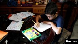 Gabriel Moncada draws at his home in Caracas, Venezuela October 15, 2018. Picture taken October 15, 2018. (REUTERS/Marco Bello)